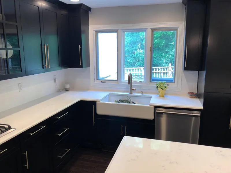 Black shaker kitchen with white countertops and a gas cooktop